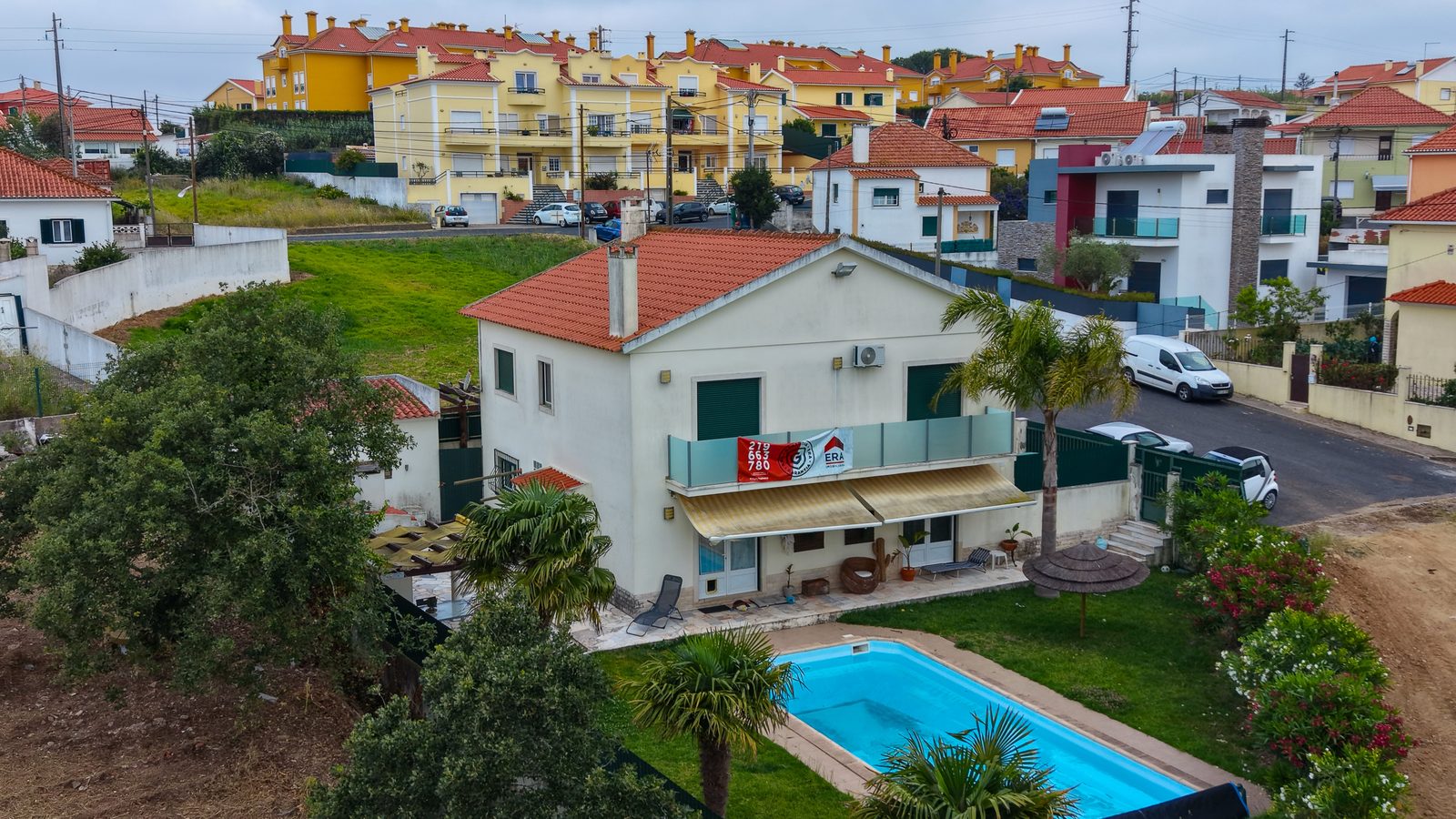 Vista aérea frontal da moradia em Alcainça, com varanda e piscina