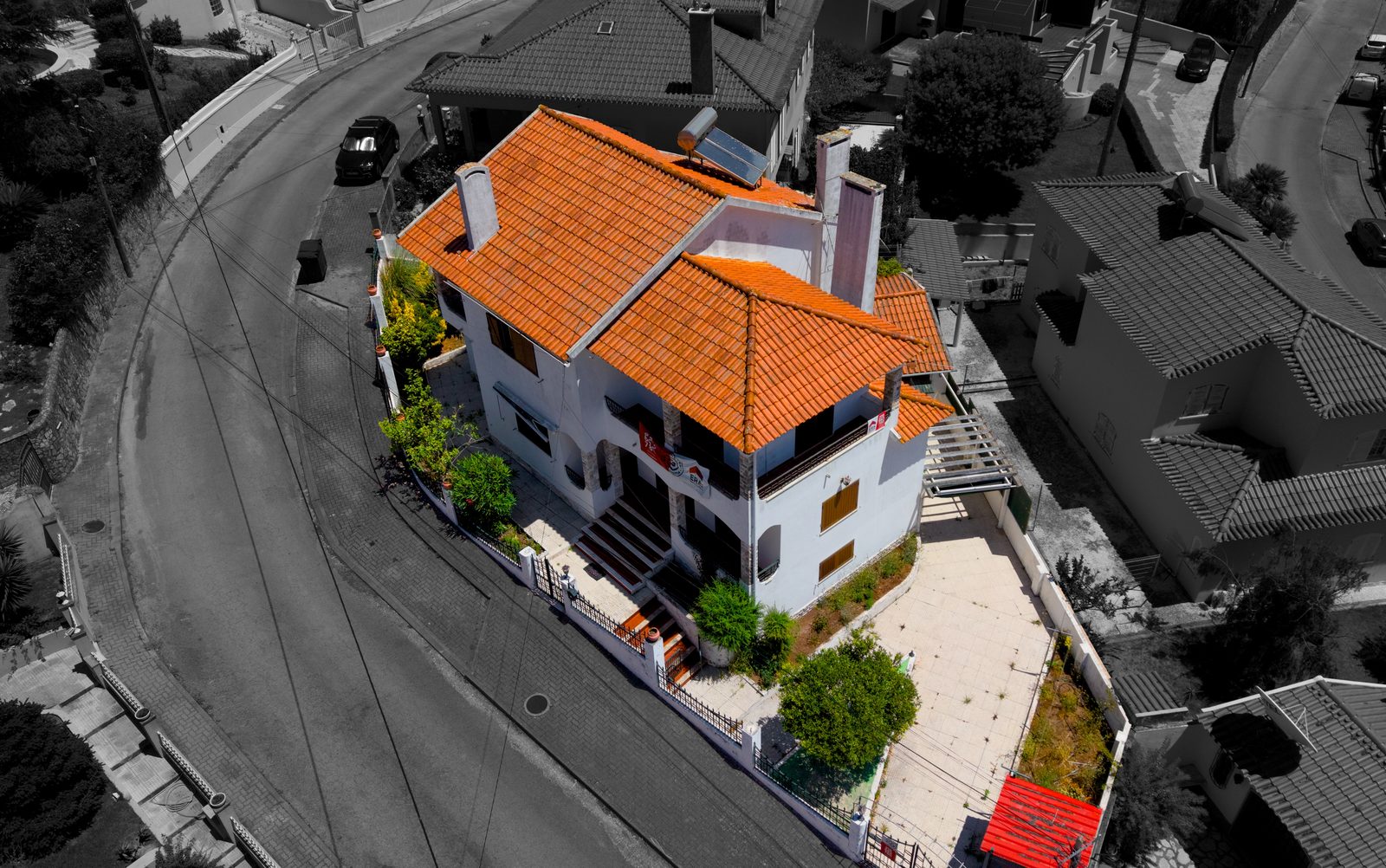 Fachada da moradia realçada a cor sobre a envolvente a preto e branco